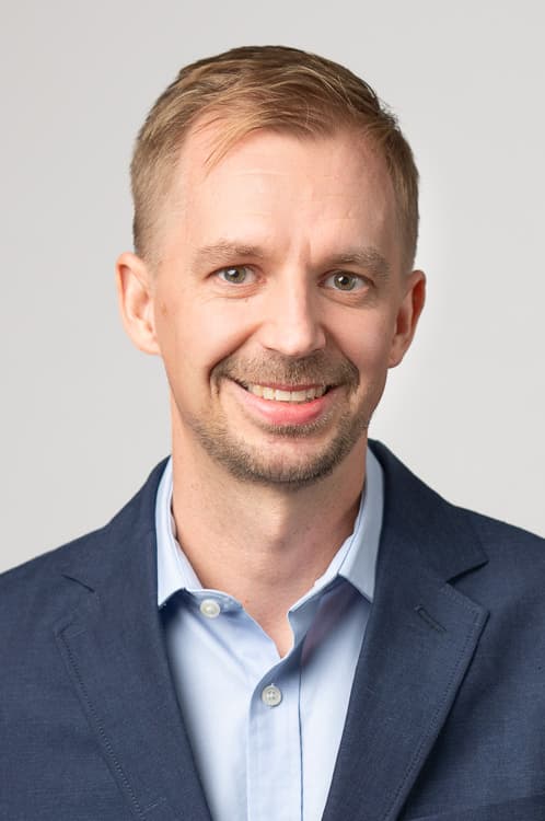 A light blue button-up shirt worn under a navy blue blazer.