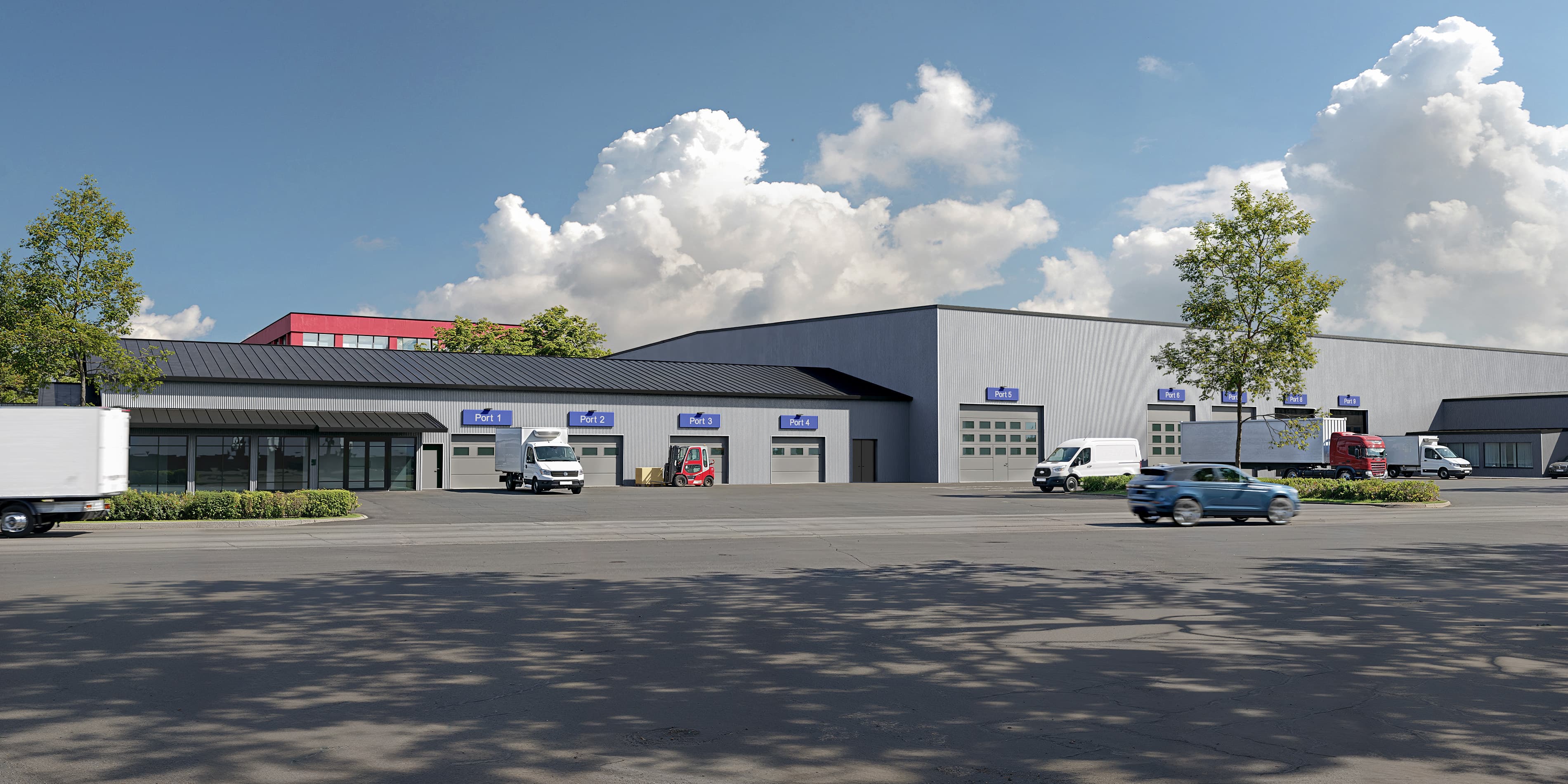 A modern industrial building featuring several garage doors, parked and moving vehicles, trees, and a partly cloudy sky.